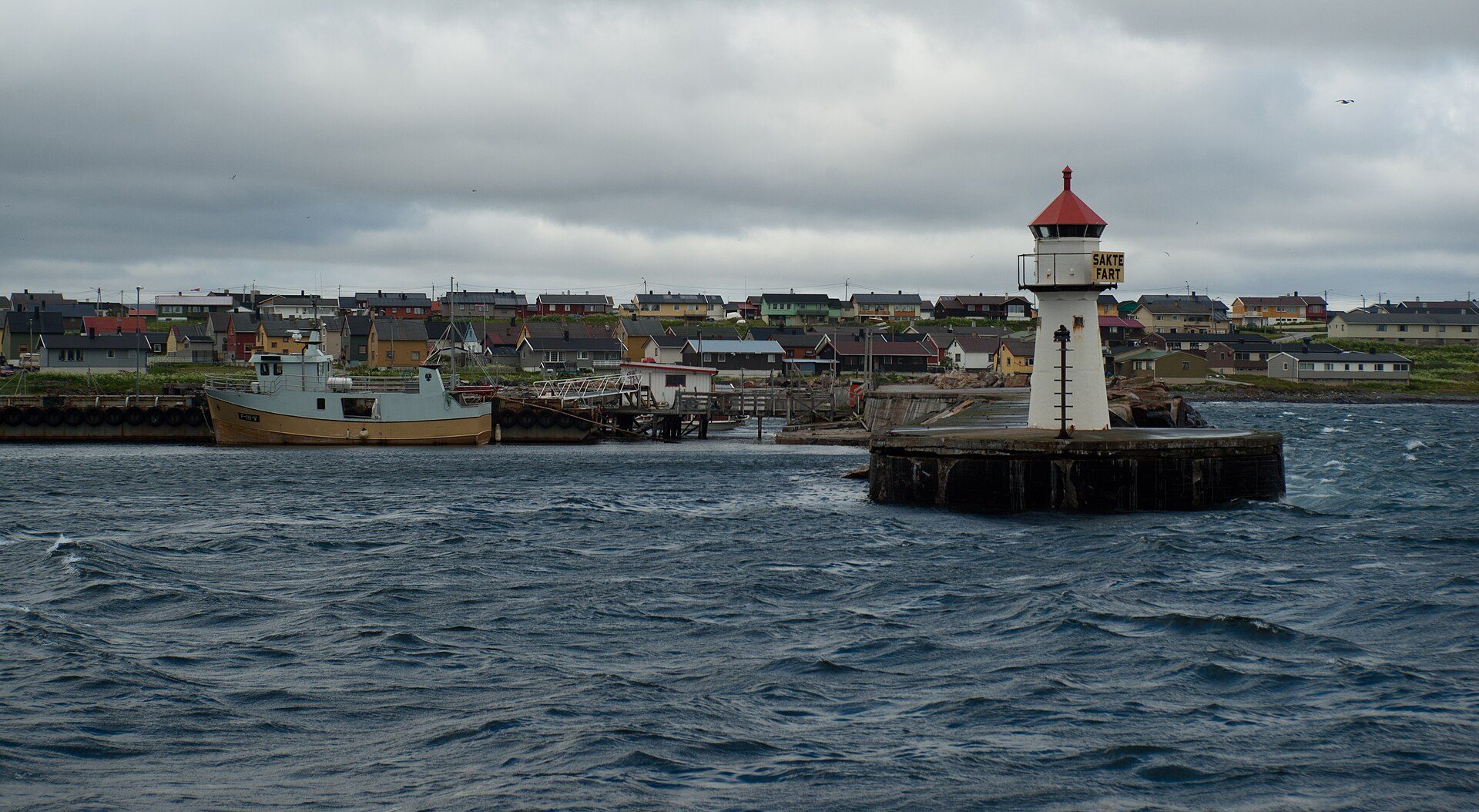 Vardø havn med fiskebåt og fyrlykt
